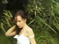 Брюнетка позирует в открытом поле