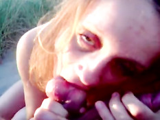 Возбуждённая девушка делает минет на пляже