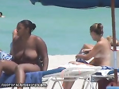 Жёлтые стринги  пляжной девочки загорающей топлесс