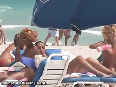 Жёлтые стринги  пляжной девочки загорающей топлесс