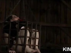 Связанная брюнетка с завязанным ртом томится в клетке