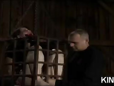 Связанная брюнетка с завязанным ртом томится в клетке