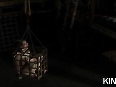 Связанная брюнетка с завязанным ртом томится в клетке