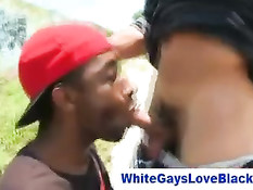 Чёрный парень в красной шапочке на стоянке сосёт хуй белому