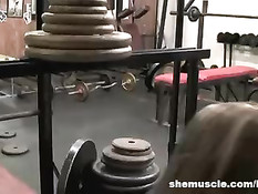 Гибкая девушка с бритой пилоткой занимается в тренажерном зале