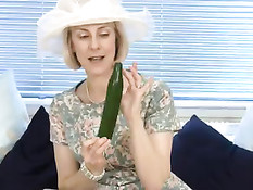 Сексуально озабоченная дамочка суёт в пизду длинный огурец