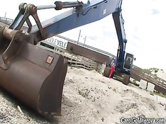 Девушка с большой грудью Кэрол Голднерова позирует у экскаватора