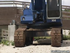 Девушка с большой грудью Кэрол Голднерова позирует у экскаватора