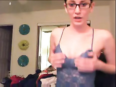 Девушка в очках примеряет наряды и показывает большую грудь