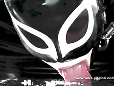 Рабыня в маске и латексном костюме вылизывает ноги своей госпоже