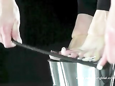 Рабыня в маске и латексном костюме вылизывает ноги своей госпоже