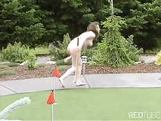 Девушка с бритой писькой летом во дворе играет в гольф обнажённой