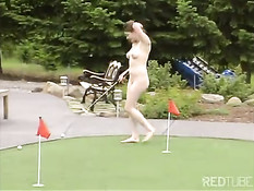 Девушка с бритой писькой летом во дворе играет в гольф обнажённой