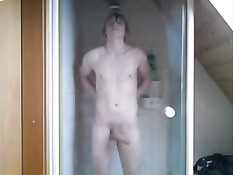 Мальчик с возбуждённым членом принимает душ в прозрачной кабине