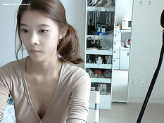 Девушка с тату на груди и пирсингом в пупке позирует у веб-камеры