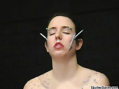 Втыкает иголки в обнажённую девку и капает расплавленным воском