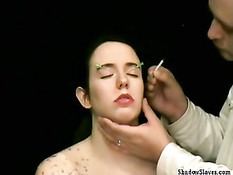 Втыкает иголки в обнажённую девку и капает расплавленным воском