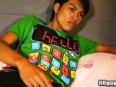 Азиатский гей с татуировкой раздевается на кровати и дрочит член