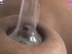 Беременная чернокожая женщина трясёт грудью и выдаивает молоко