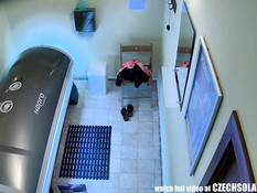 Молодая блондинка с татуировкой на пояснице загорает в солярии