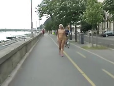 Молодая голая блондинка прогуливается по городу смущая прохожих