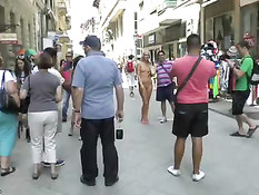 Молодая голая блондинка прогуливается по городу смущая прохожих