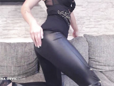 Молодая девка с красными волосами позирует в латексных легинсах