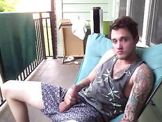 Симпатичный молодой гей с татуировками дрочит член на балконе