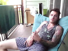 Симпатичный молодой гей с татуировками дрочит член на балконе