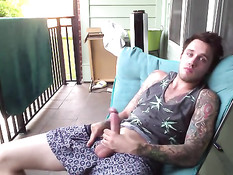 Симпатичный молодой гей с татуировками дрочит член на балконе
