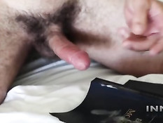 Гомосексуальный парень с татуировками в постели дрочит свой хуй