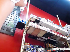 Продавщица в чёрных трусиках задирает юбку и показывает киску