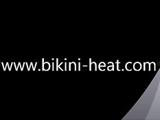 Соблазнительная девушка в микро бикини позирует на летнем пляже