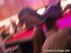 Горячая блондинка в латексном костюме танцует стриптиз на сцене