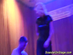 Горячая блондинка в латексном костюме танцует стриптиз на сцене