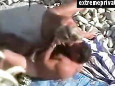 Пожилая семейная пара занимается любовью на каменистом пляже