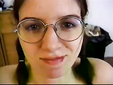 Очкастая девка с косичками усиленно выдрачивает сперму из члена