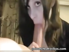 Девка в чёрном платье держит рукой длинный член и делает минет