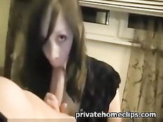 Девка в чёрном платье держит рукой длинный член и делает минет