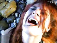 Мужик ебёт привязанную к камню рыжую рабыню в сетчатых чулках