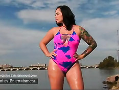 Татуированная брюнетка с большой жопой позирует на берегу озера