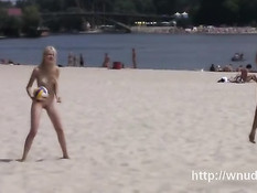 Две русские девчонки на пляже играют с мячом в обнажённом виде