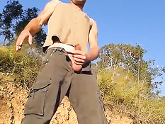 Очкарик гей достаёт из штанов свой член и надрачивает на природе