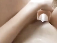 Девушка вставляет фаллос в свою гладко выбритую киску и снимает