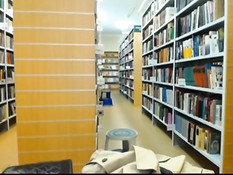 Развратная блондиночка в чёрном платье обнажается в библиотеке