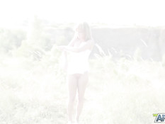 Голубоглазая молодая блондинка в чулках мастурбирует клитор в поле