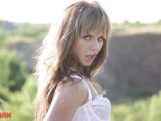 Голубоглазая молодая блондинка в чулках мастурбирует клитор в поле