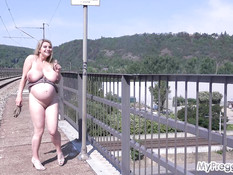 Грудастая беременная блондинка ласкает своё обнажённое тело на мосту